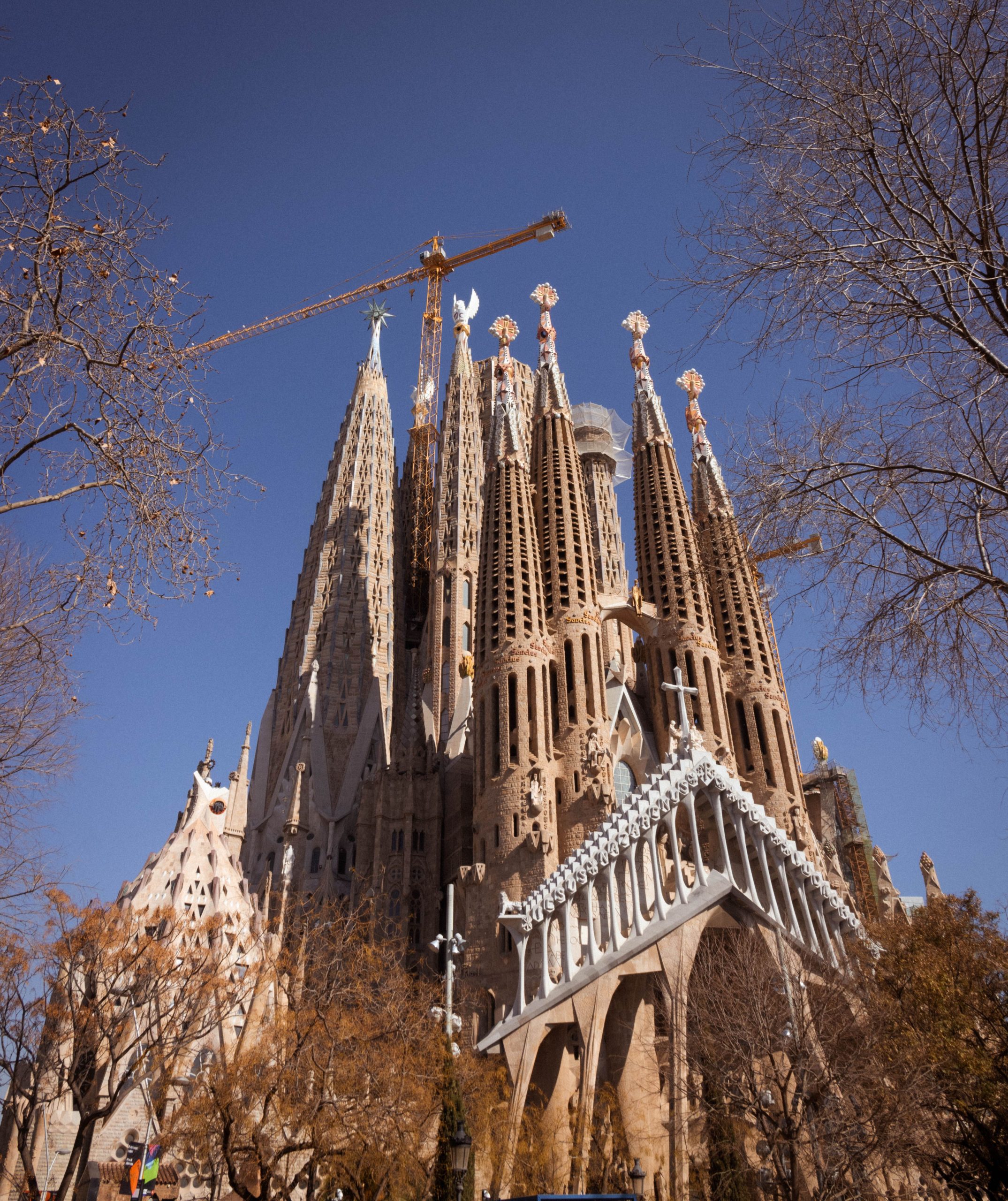 A breathtaking view of the iconic Sagrada Familia Basilica under a clear blue sky in Barcelona.